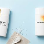 Dua botol BREVA sunscreen, mineral memantulkan sinar UV dan chemical menyerapnya, di latar biru muda. Pilihan perlindungan kulit premium BREVA.